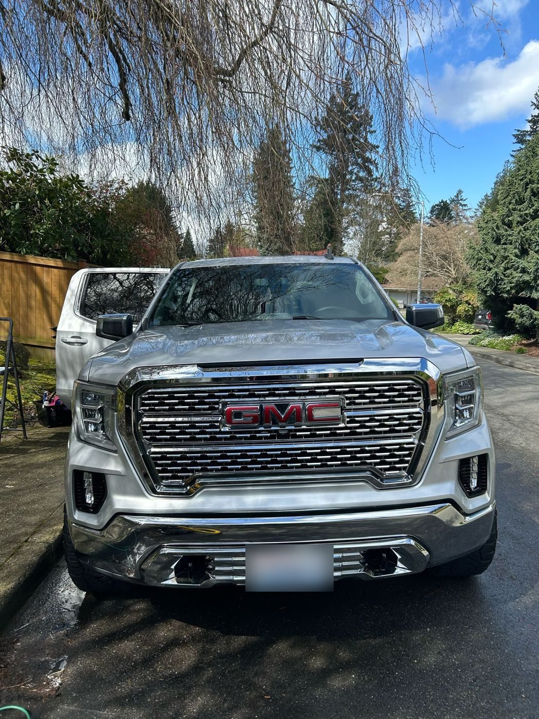 Silver GMC Sierra pickup, front grille, freshly washed