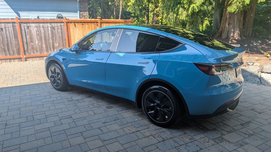 Blue Tesla Model Y on a paver driveway after a detail