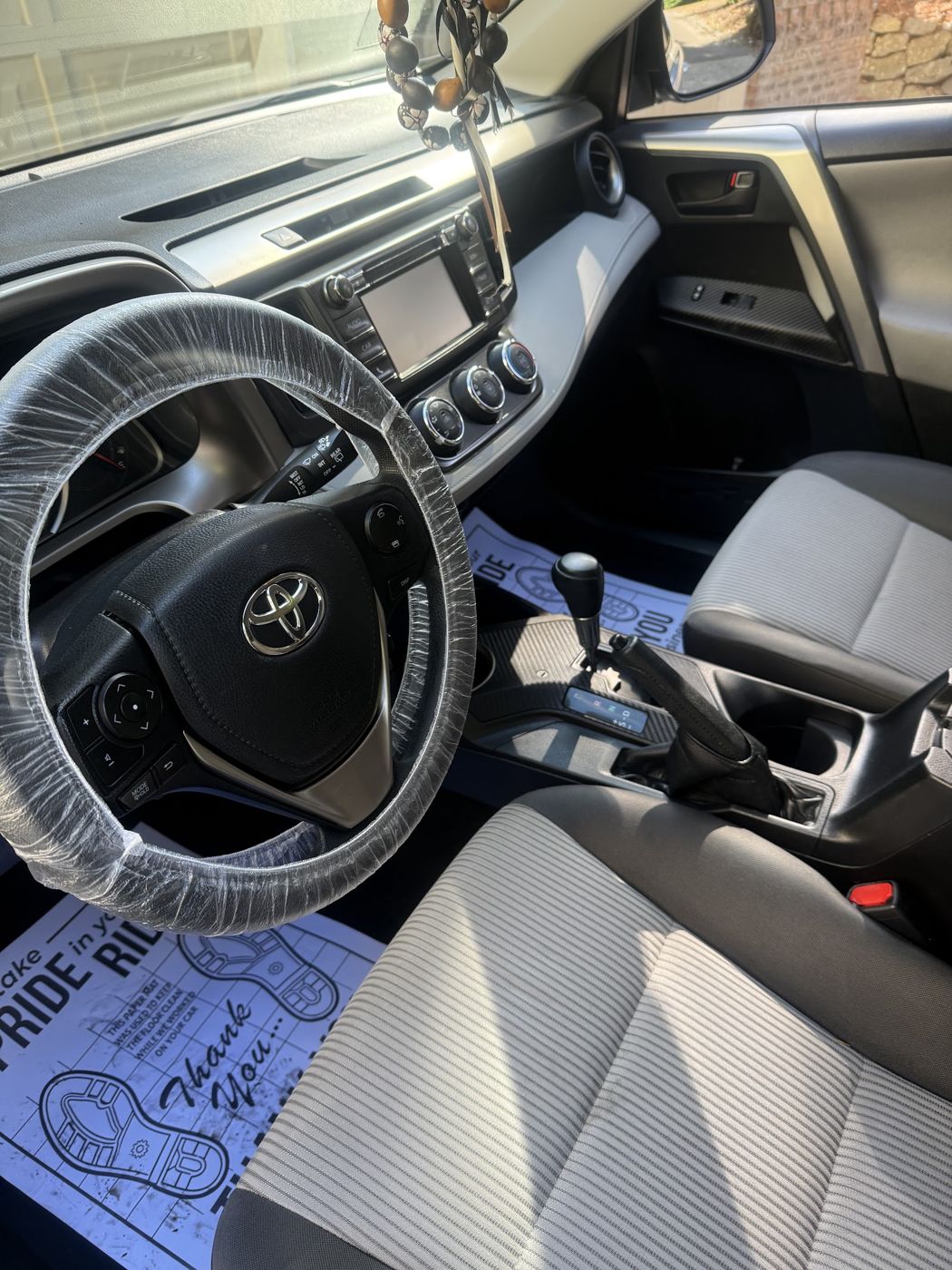 Toyota interior after a detail with steering-wheel cover and paper floor mat