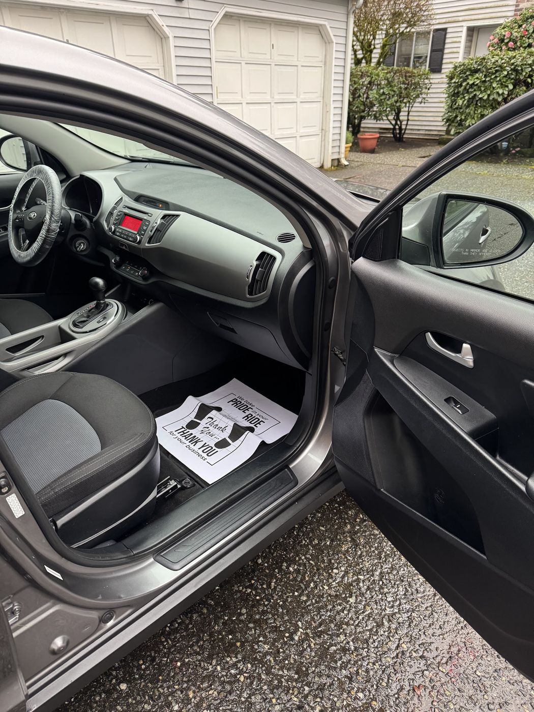 Kia Sportage interior seen through the open driver's door
